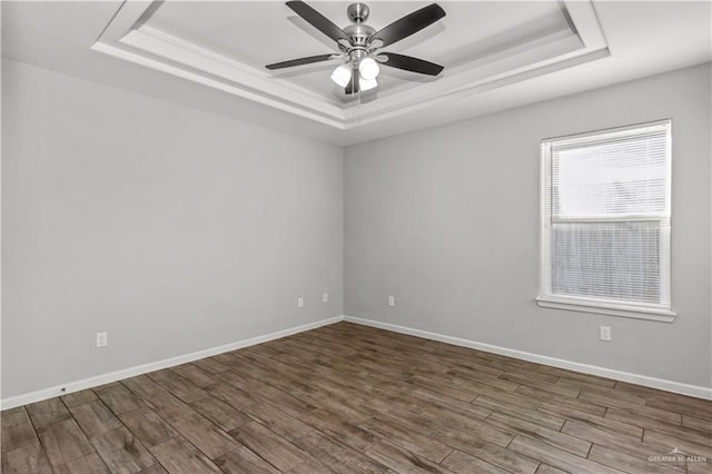 spare room with hardwood / wood-style floors, ceiling fan, and a tray ceiling