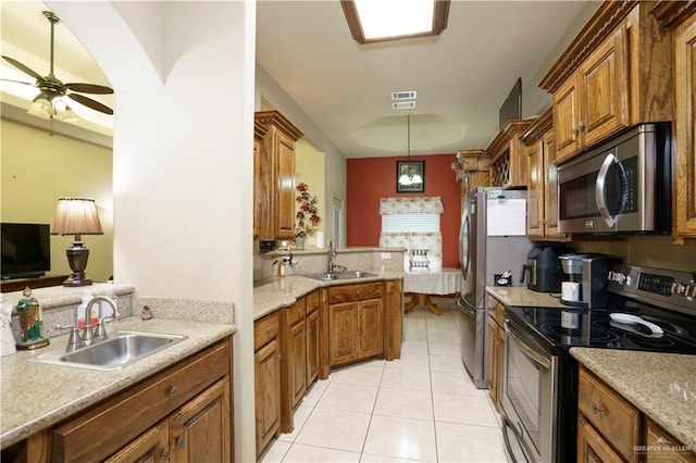 1110 E 8th St N, San Juan, TX 78589 - kitchen featuring appliances with stainless steel finishes, a sink, light tile patterned floors, and a peninsula