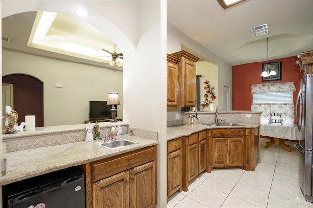 1110 E 8th St N, San Juan, TX 78589 - kitchen featuring a sink, arched walkways, freestanding refrigerator, and brown cabinets