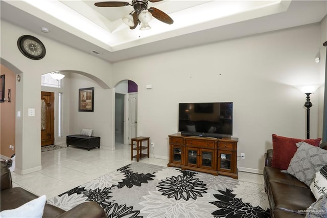 1110 E 8th St N, San Juan, TX 78589 - living room with arched walkways, a ceiling fan, light tile patterned floors, a raised ceiling, and baseboards