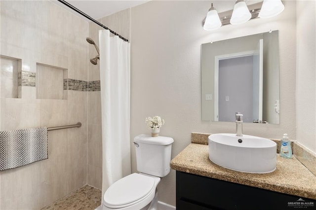 bathroom featuring vanity, toilet, and curtained shower