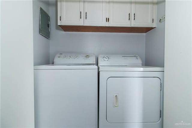 laundry room featuring cabinets, washing machine and dryer, and electric panel