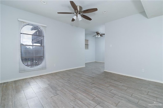 empty room with ceiling fan and light hardwood / wood-style flooring