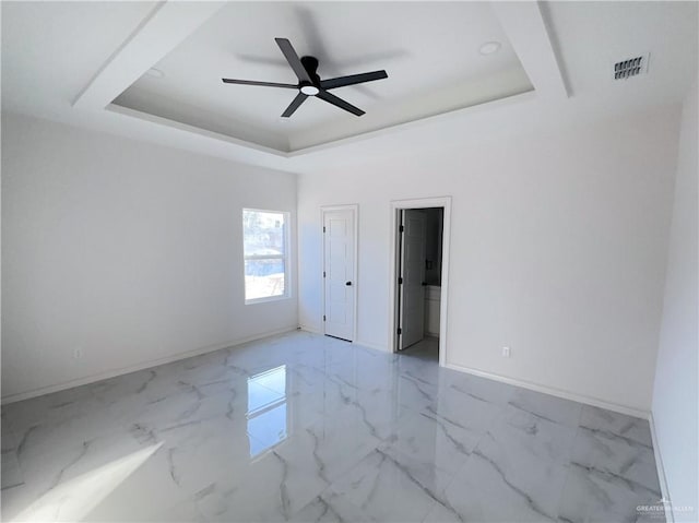 unfurnished room featuring a tray ceiling and ceiling fan