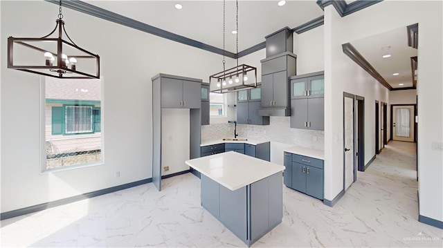 513 E Hawk Ave, Pharr, TX 78577 - kitchen featuring crown molding, a chandelier, gray cabinets, a center island, and light marble finish flooring