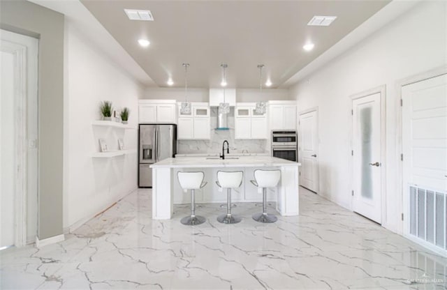 kitchen featuring a breakfast bar, light countertops, marble finish floor, and appliances with stainless steel finishes