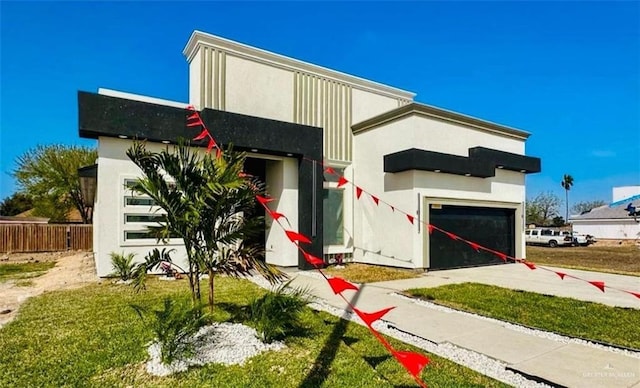 modern home with stucco siding, a garage, concrete driveway, and fence