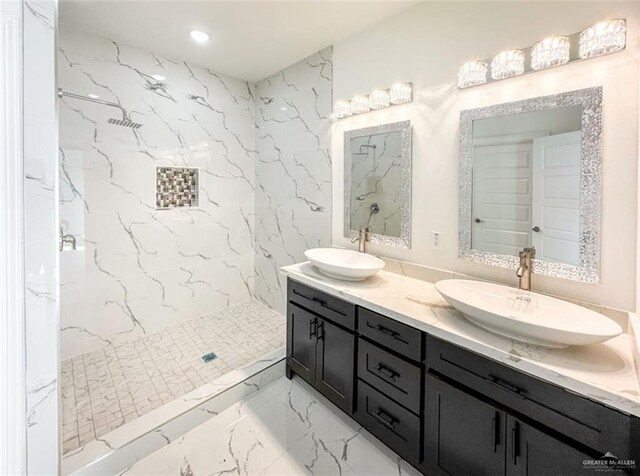 full bathroom featuring a marble finish shower, marble finish floor, double vanity, and a sink