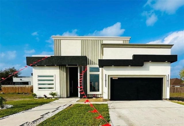 contemporary home with stucco siding, a garage, concrete driveway, and fence