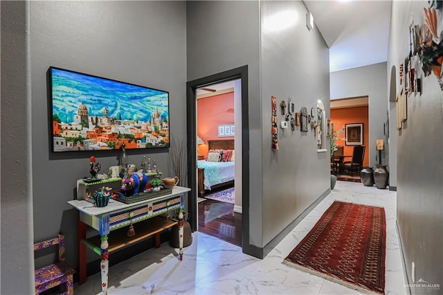 corridor with marble finish floor and baseboards