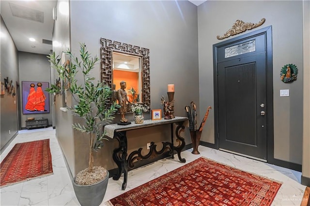 entrance foyer with marble finish floor and baseboards