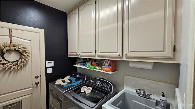 washroom featuring cabinets, washer and clothes dryer, and sink