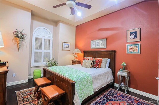 bedroom with a ceiling fan, dark wood-style flooring, and baseboards