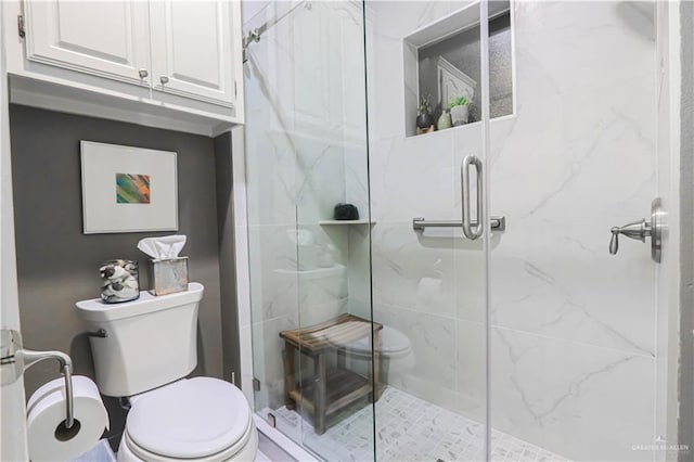 bathroom featuring a shower stall and toilet