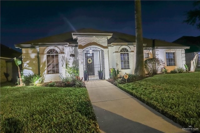 view of front of house with a gate and a yard