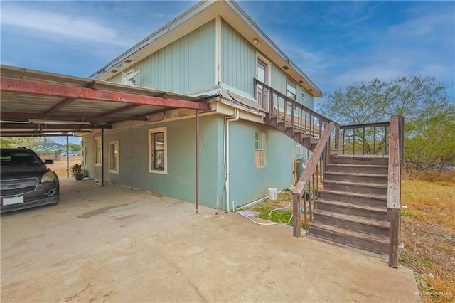 view of side of home with stairs and a carport