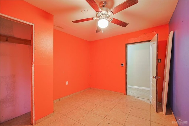 unfurnished bedroom with light tile patterned flooring, ceiling fan, and a closet