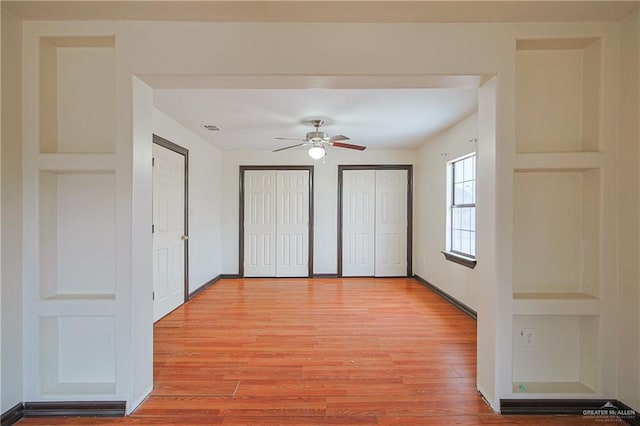 unfurnished bedroom with multiple closets, ceiling fan, and light hardwood / wood-style flooring