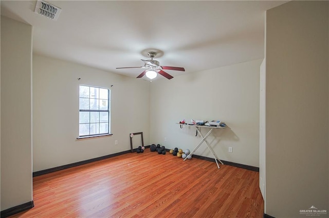 empty room featuring baseboards, ceiling fan, visible vents, and light wood-style floors