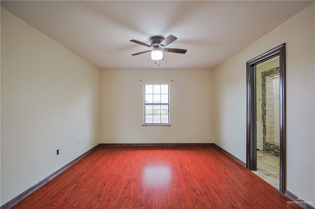 spare room with a ceiling fan, baseboards, and wood finished floors