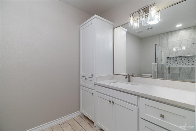 bathroom with walk in shower, vanity, and toilet