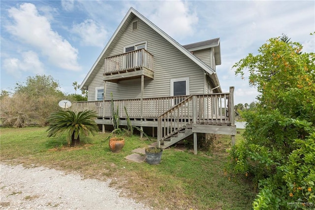 rear view of property with a balcony and a deck