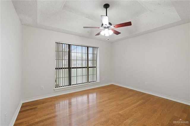 unfurnished room with baseboards, a textured ceiling, ceiling fan, and wood finished floors