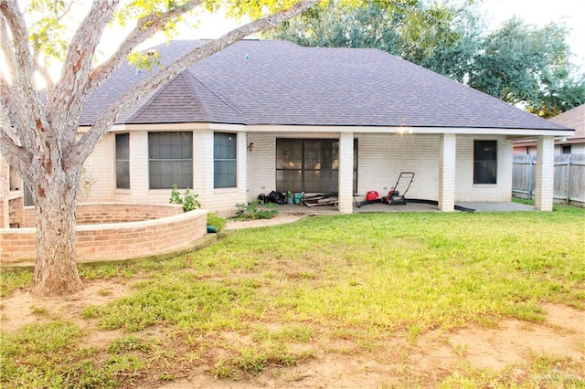 rear view of house featuring a yard and a patio