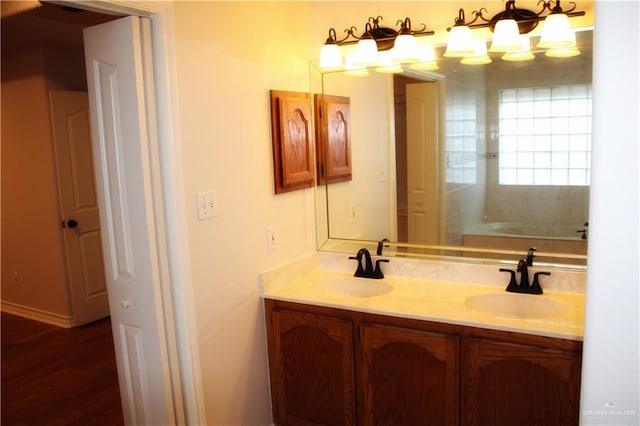 bathroom with hardwood / wood-style floors, vanity, and a tub to relax in