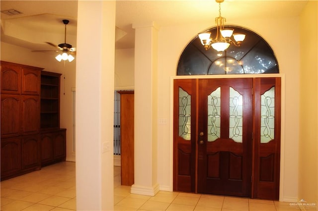 entrance foyer with ceiling fan with notable chandelier and light tile patterned floors