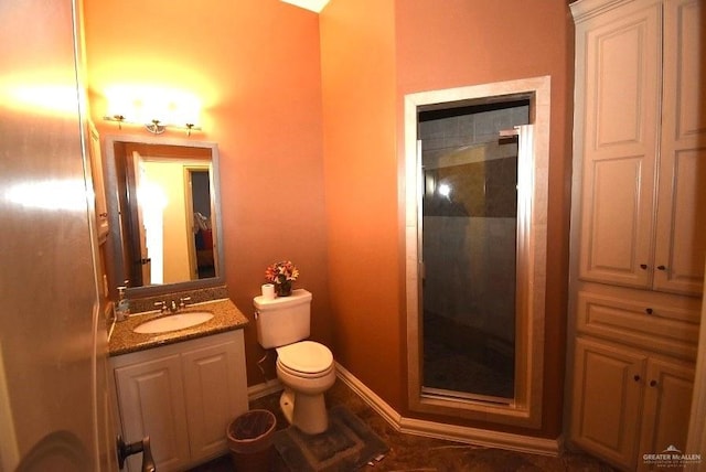 bathroom with a shower with door, vanity, and toilet