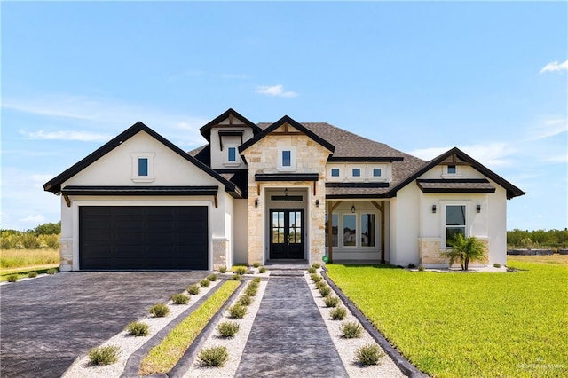 8100 Coyote Dr, Mission, TX 78574 - view of front of home with french doors, stone siding, stucco siding, decorative driveway, and a front lawn