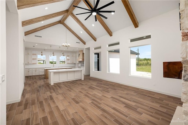 8100 Coyote Dr, Mission, TX 78574 - kitchen featuring premium range hood, beamed ceiling, white cabinetry, a chandelier, and open floor plan
