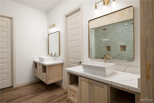 8100 Coyote Dr, Mission, TX 78574 - bathroom featuring a marble finish shower, wood finished floors, and two vanities