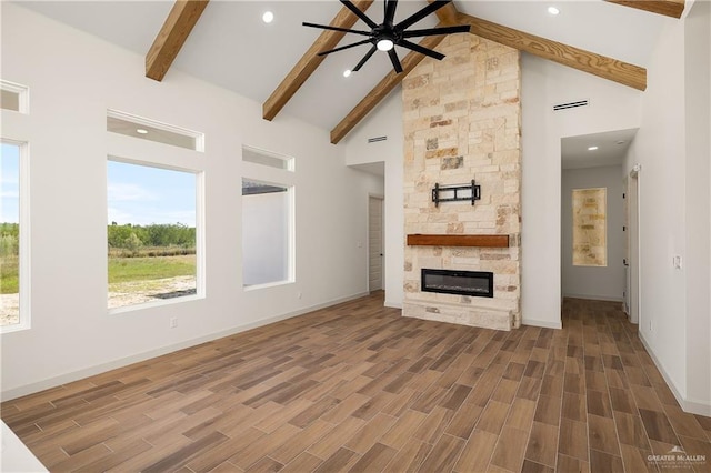 8100 Coyote Dr, Mission, TX 78574 - unfurnished living room featuring a ceiling fan, beamed ceiling, wood finished floors, high vaulted ceiling, and a fireplace