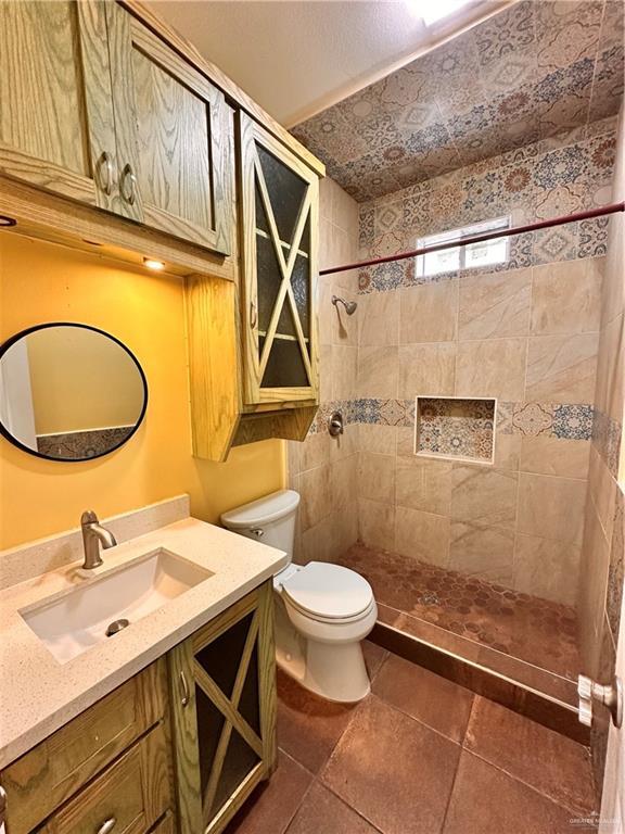 2401 S Gardenia St, Pharr, TX 78577 - bathroom with toilet, a tile shower, and vanity