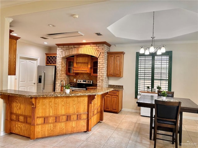 2401 S Gardenia St, Pharr, TX 78577 - kitchen featuring appliances with stainless steel finishes, brown cabinetry, tasteful backsplash, dark stone countertops, and a kitchen breakfast bar