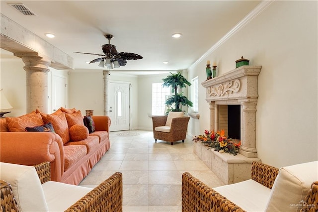 living room featuring ceiling fan, ornamental molding, a high end fireplace, and ornate columns