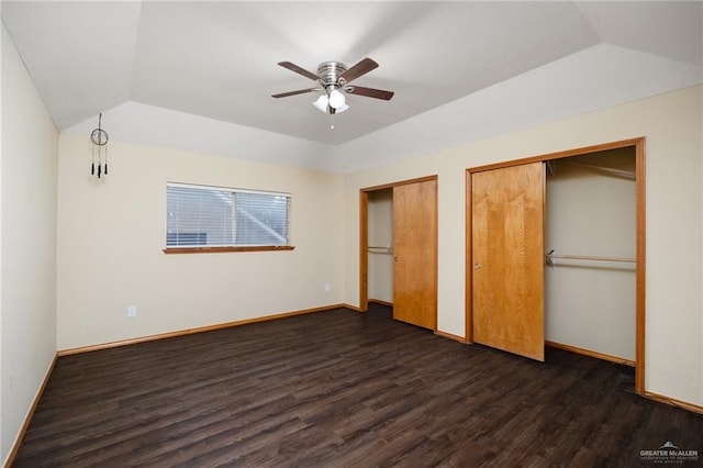 unfurnished bedroom with lofted ceiling, multiple closets, ceiling fan, and dark hardwood / wood-style floors