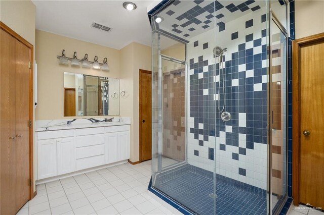 bathroom featuring a shower with door, vanity, and tile patterned flooring