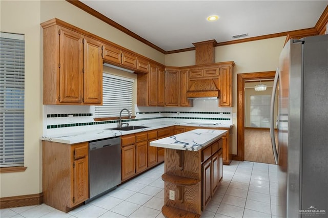 kitchen featuring a center island, stainless steel appliances, tasteful backsplash, and sink