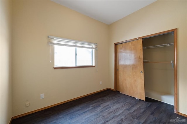 unfurnished bedroom with dark hardwood / wood-style flooring and a closet