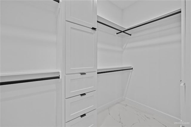 walk in closet featuring marble finish floor