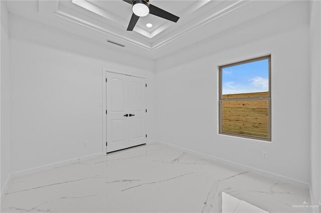 unfurnished room featuring marble finish floor, a raised ceiling, visible vents, and baseboards