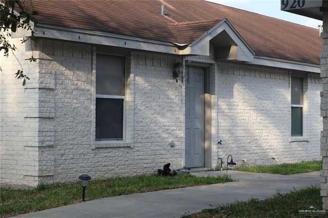 view of side of home featuring roof with shingles