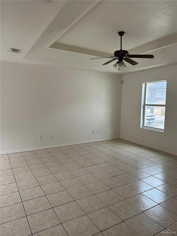 spare room with visible vents, baseboards, a raised ceiling, light tile patterned floors, and ceiling fan