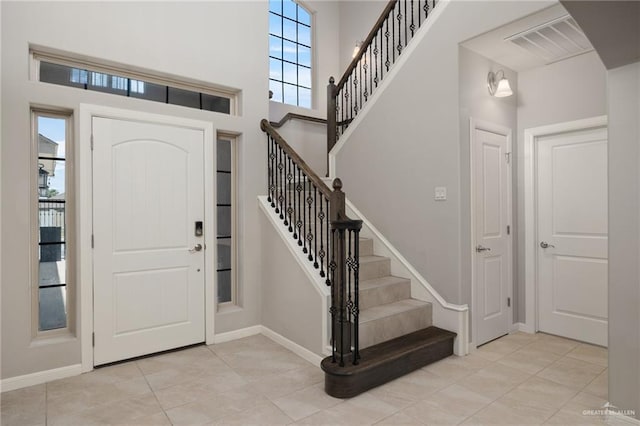 tiled foyer entrance with a high ceiling