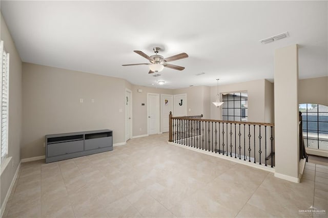 empty room featuring ceiling fan and plenty of natural light