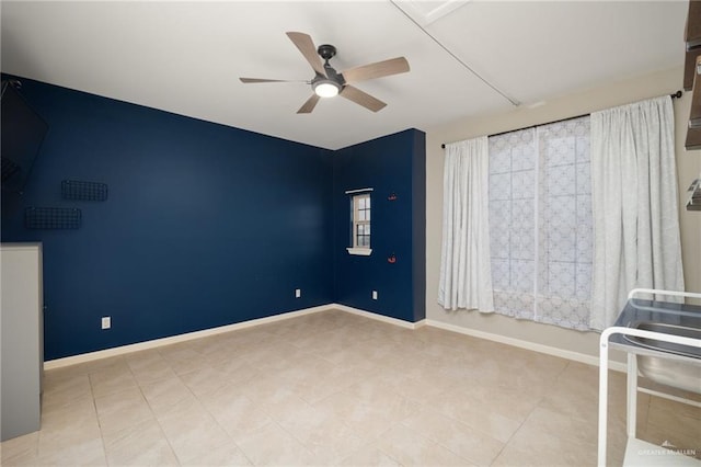 tiled spare room featuring ceiling fan