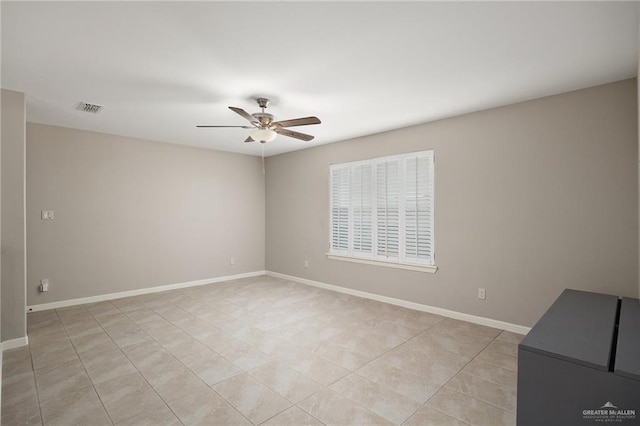 tiled spare room with ceiling fan